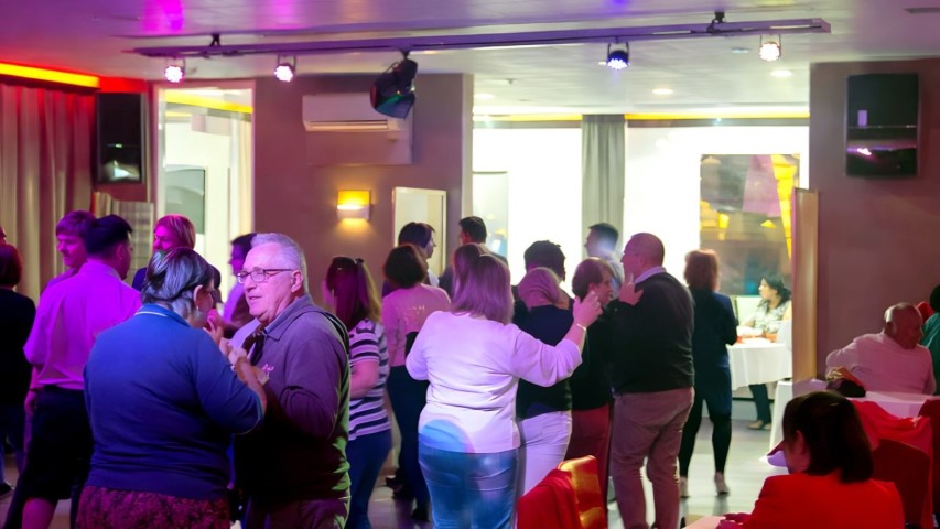 Invitados de todas las edades bailando en evento familiar