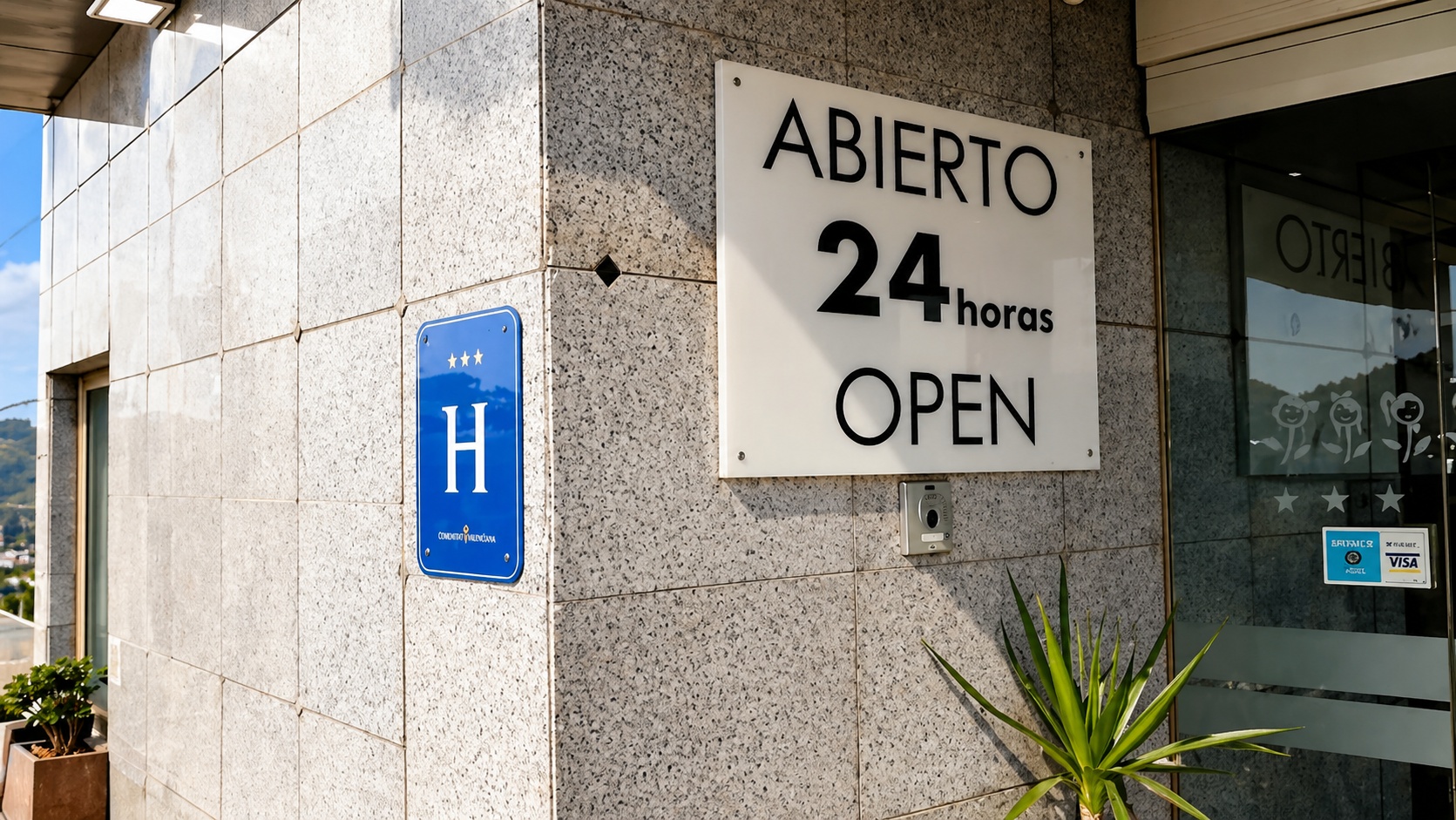 Cartel ABIERTO 24 horas OPEN en la entrada del hotel