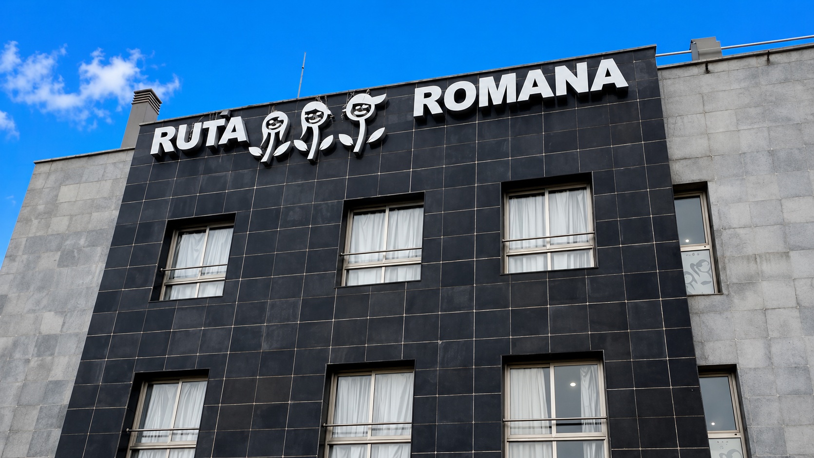 Cartel RUTA ROMANA con logo del hotel en fachada negra