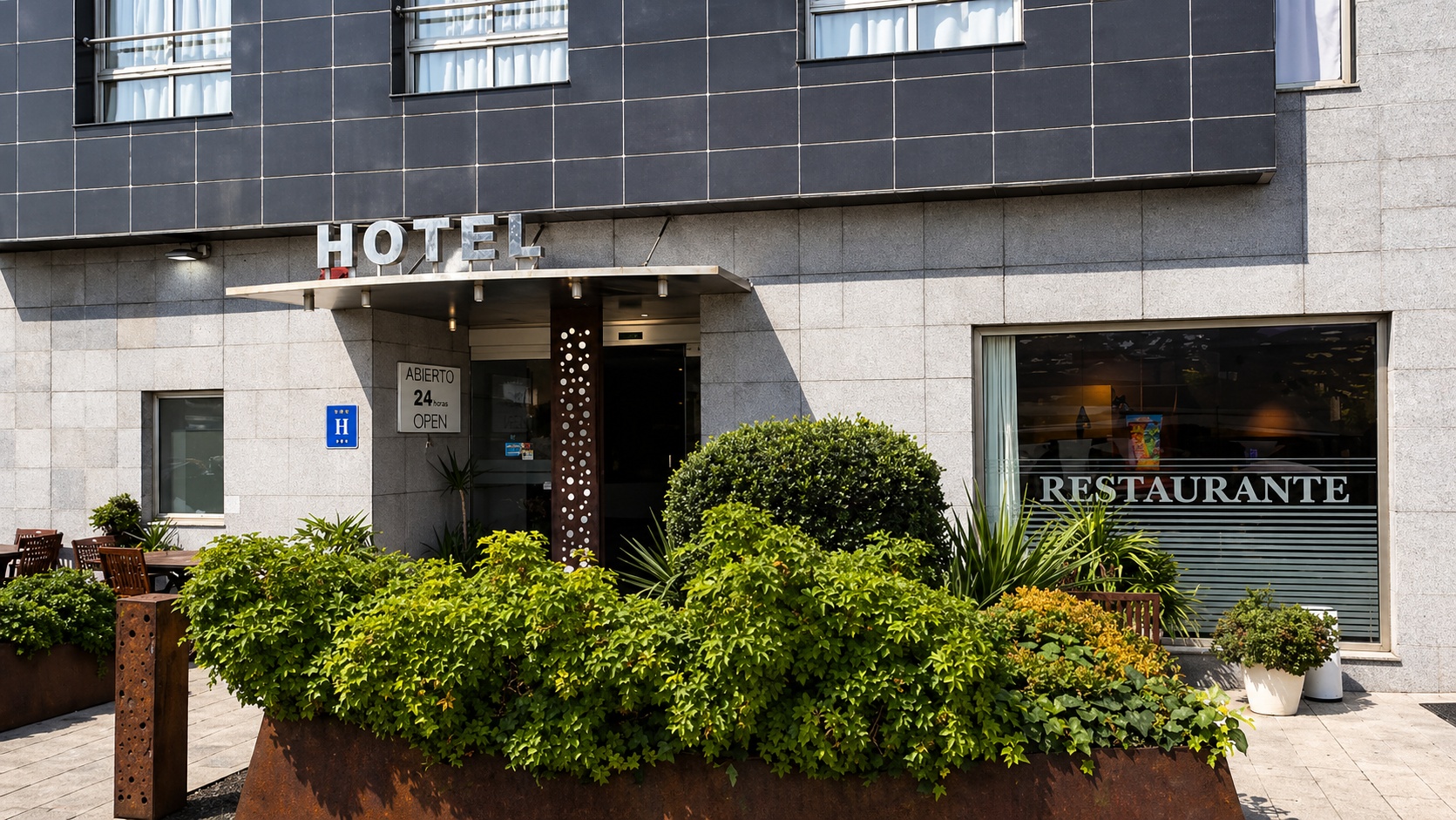 Fachada completa del hotel con jardinería cuidada en Sagunto