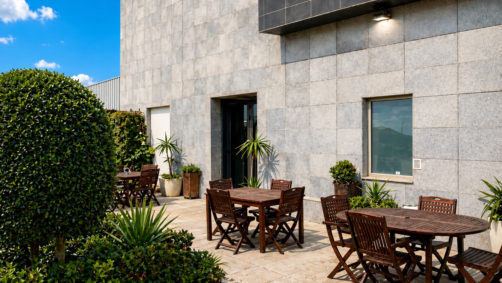 Terraza lateral con fachada de piedra del hotel