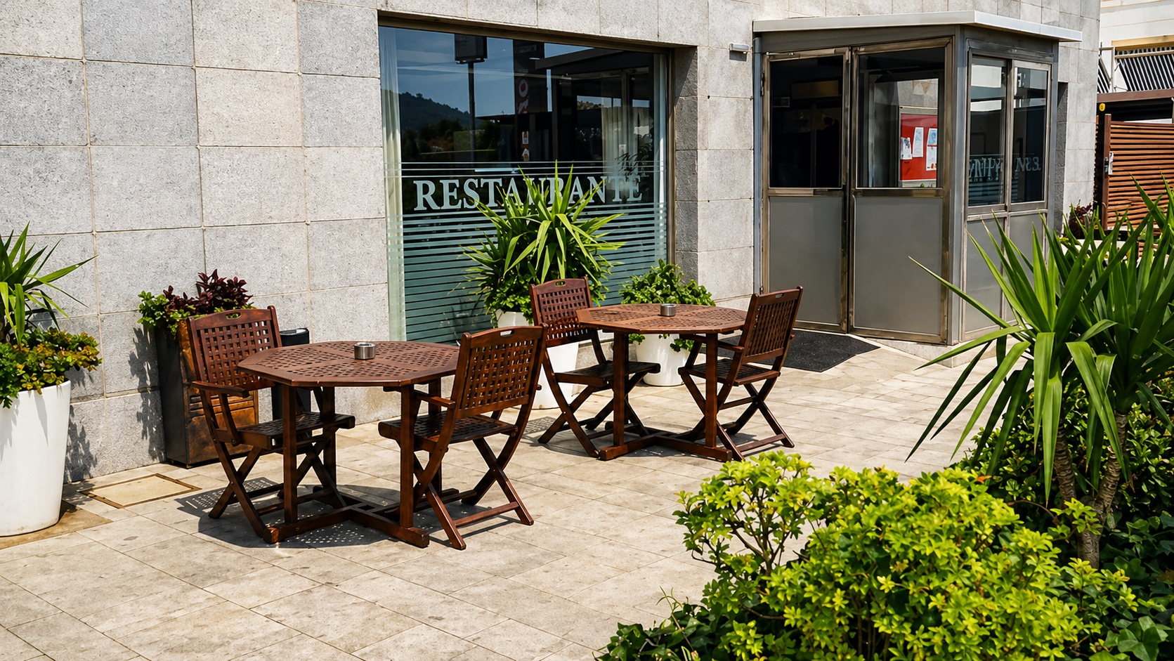 Terraza exterior con mesas de madera del hotel