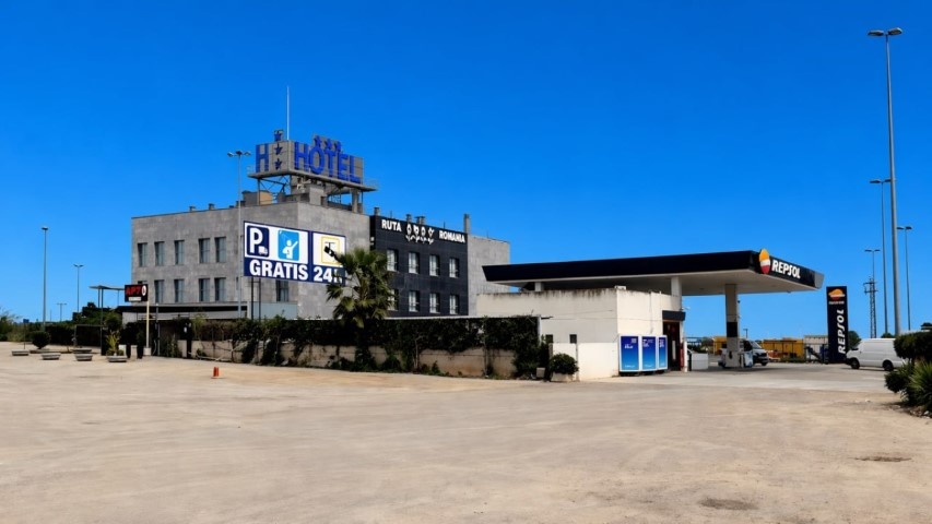 Panorámica del parking vacío mostrando el hotel y el cartel de parking gratis