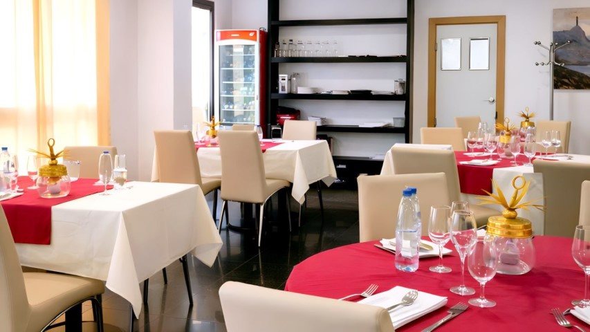 Sala completa del restaurante con mesas redondas y rectangulares preparadas