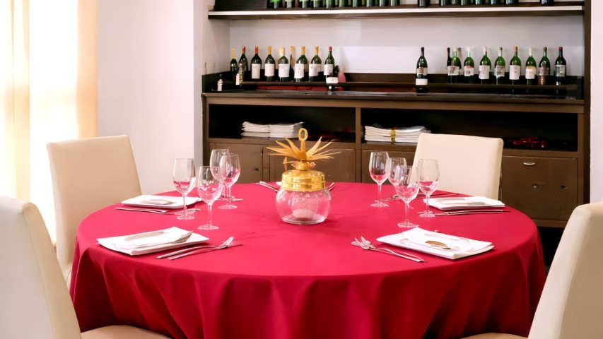 Mesa redonda preparada con estantería de vinos al fondo