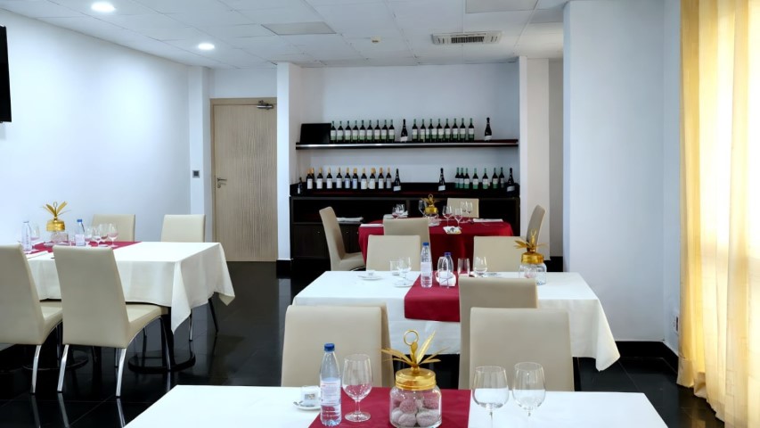 Sala del restaurante con estantería completa de vinos al fondo