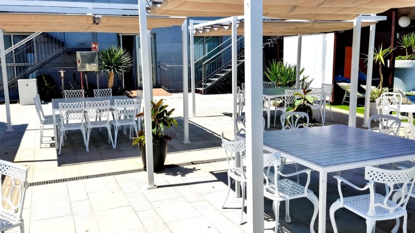 Terraza con edificio blanco de habitaciones al fondo